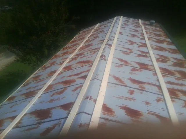 Rusted metal roof panels with new wood purlins before replacement — Storm Damage Roof Repair in Saltville by Roofing Brothers